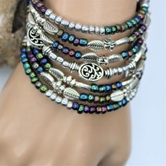 "Fun and festive this seven layer bracelet is sure to make a fresh statement. The layered silver and colored beads give that fun boho vibe which will compliment nearly all outfits, and is perfect for everyday, beach vacations, or special occasions. The one-size-fits-all feature makes this a great gift for any woman. Made with memory wire, a kind of wire that never loses its shape. You simply wrap the bracelet around your wrist. The bracelet coils wrap around the wrist and gives the impression of Bohemian Multi-strand Beaded Bracelets With Silver Beads, Bohemian Nickel-free Beaded Metal Bracelets, Silver Beaded Bracelets Bohemian Style, Multicolor Bohemian Beaded Bracelets With Silver Beads, Bohemian Metal Beaded Stackable Bracelets, Stackable Bohemian Metal Beaded Bracelets, Bohemian Silver Beaded Bracelets With Spacer Beads, Bohemian Multicolor Bracelets With Silver Beads, Silver Beaded Bohemian Bracelets