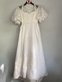 a white dress hanging up against a wall