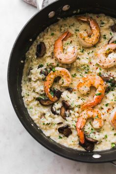 shrimp and rice with mushrooms in a skillet on a white counter top, ready to be eaten