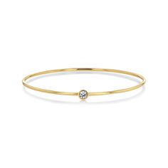 Meet our perfect Diamond Bezel Set Bangle, crafted with a 0.25ct Post-Consumer Recycled Brilliant Cut Diamond and 7grams of solid 14k gold for enduring beauty and wear. This sparkling and fun bangle features a meticulously bezel-set diamond that radiates brilliance. Its comfortable design makes it perfect for everyday Everyday Diamond Accents Bangle, Minimalist Gold Bangle With Diamond Accents, Classic Gold Bangle With Single Diamond, 14k Gold Bangle With Diamond Accents, Timeless Gold Bangle With Diamond Accents, Wire Bangles, Bezel Set Diamond, Diamond Bangle, Bezel Diamond