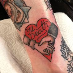 a person with a tattoo on their leg holding a heart and two hands that say i love you