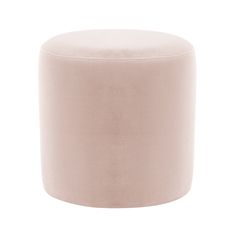 a round ottoman with a light pink velvet finish