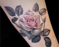 a rose tattoo on the arm with leaves