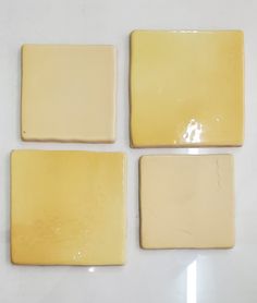 four square yellow tiles sitting on top of a white table