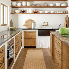 a kitchen filled with lots of wooden cabinets and counter top space next to a sink