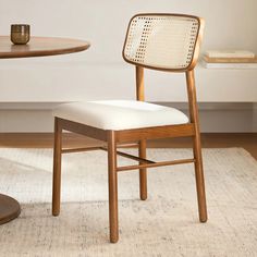 a wooden chair sitting on top of a rug next to a table