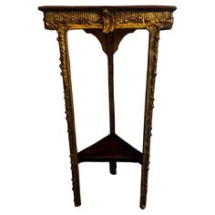 an ornate wooden table with gold paint and carvings on the top, against a white background