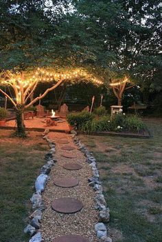 an image of a garden with lights on the trees and stones in the path leading to it