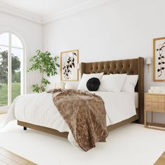 a bedroom with white walls and wooden flooring has a large bed in the center