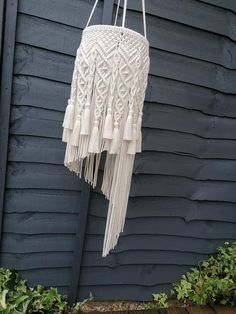 a white macrame hanging on the side of a house