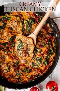 a skillet filled with chicken and spinach covered in cheese, sauce and herbs