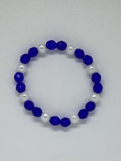 Material: Clear String Color: Royal Blue and White Type: Bracelet Style: Glamorous Blue Crystal Bracelet With Faceted Beads, Elegant Blue Beaded Bracelets With Faceted Beads, Elegant Blue Beaded Bracelet With Faceted Beads, Blue Faceted Crystal Bracelets, Elegant Blue Faceted Beads Bracelet, Elegant Adjustable Blue Crystal Bracelet, Elegant Blue Faceted Beaded Bracelets, Adjustable Sapphire Crystal Jewelry, Elegant Blue Crystal Bangle Bracelet