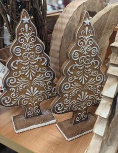 two wooden christmas trees sitting on top of a table