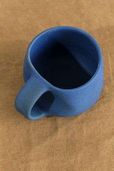 This 8 oz hand thrown stoneware coffee mug from Kati Von Lehman features an organic shaped body, and is finished with a unique and rich matte blue glaze. This mug is an eye-catching piece, that is the perfect artistic addition to any kitchen or office space. Thick Mug, Fun Mugs Ceramic, Glaze Combinations For Pottery Amaco, Pottery Coffee Cup, Pottery Painting Blue, Pottery Glaze Ideas, Mug Shapes, Aesthetic Noir, Ap Ceramics