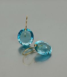 Gorgeous sparkly sky blue aquamarine earrings. The Faceted oval drops are flawless and have a beautiful sky-blue color. The drops are attached to vermeil on sterling ear wires. The earrings are elegant and have a lux look.  A truly gorgeous pair of earrings. When 14K SOLID GOLD ear wires are being used, the ear wire ends are hand-stamped as proof of being 14K solid gold. In addition, extra work was done at the end of the ear wires to prevent any sort of pain or injury while inserting them through the ear lobes. **The 14K WHITE solid gold ear wires are RHODIUM plated to prevent tarnish of the ear wires over time. * Superb  AAA+ Flawless Aquamarine Drops * Carat (40 ct.) * Birthstone: March * Stone Shap: Faceted oval  * The dimension of the stones is about 20x18mm/ 0.8x0.7 inch * Metal: 24K Modern Blue Earrings With Gemstone Accents, Light Blue Gemstone Earrings - Fine Jewelry, Blue Briolette Earrings For Formal Occasions, Elegant Blue Topaz Briolette Earrings, Luxury Blue Briolette Earrings, Modern Blue Topaz Earrings For Gift, Blue Briolette Earrings Fine Jewelry, Blue Topaz Blue Earrings, Sapphire Blue Topaz Round Earrings