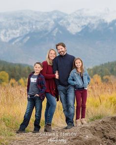 a family posing for a photo in front of mountains