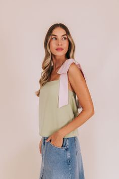 Get ready to hop into style with our Lily-Pad Lovin' Top! Crafted with silky satin material and adorned with playful bow straps. Available in a refreshing green hue with playful pink straps. Upgrade your wardrobe with this fun addition! Details Bow straps Sily/satin material Sizing Approximate measurements: SIZE LENGTH BUST Small 21" 36" Medium 22" 38" Large 23" 40" Fabric has no stretchModel is 5’8 wearing small Material 97% Polyester 3% SpandexHand wash coldHang to dry Green Tops With Tie Straps For Day Out, Chic Spring Tops With Bow Straps, Chic Tops With Bow Straps For Day Out, Spring Party Tops With Ribbon, Feminine Ribbon Tops For Spring, Feminine Tops With Ribbon For Spring, Pink Tops With Ribbon For Spring, Chic Spring Tops With Ribbon, Summer Tops With Bow Straps