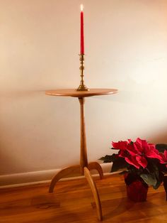 a small table with a candle on it and a potted plant next to it