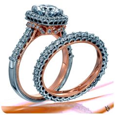 two wedding rings with diamonds on each side and an engagement ring in the middle, sitting next to each other