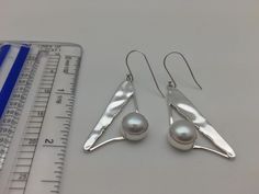 Hi everyone, just wanted to let you know we are open and shipping daily. Beautifully crafted handmade pearl and sterling silver dangle earrings. Features perfectly matched hand picked Pearls in a stunning sterling silver setting. This line of pearl jewelry makes excellent brides made gifts and has been a top seller in our San Francisco jewelry store for years. 8 grams weight Minimalist Hypoallergenic Pearl Earrings For Formal Events, Minimalist Nickel-free Pearl Earrings For Formal Occasions, Elegant Sterling Silver Pearl Earrings With Ear Wire, Minimalist Silver Pearl Earrings, Silver Pearl Minimalist Earrings, Formal Sterling Silver Pearl Earrings, White Sterling Silver Pearl Earrings For Anniversary, Elegant Sterling Silver Pearl Earrings Nickel Free, Elegant Sterling Silver Nickel-free Pearl Earrings