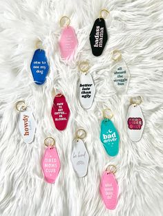 many different colored dog tags on a white fur surface