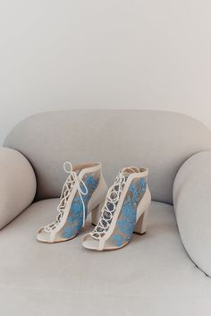 a pair of blue and white shoes sitting on top of a couch