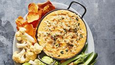 a platter filled with different types of vegetables and crackers on top of it