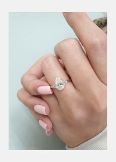 a woman's hand with pink manicured nails and a ring on her finger