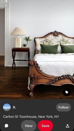 a bedroom with white walls and wood flooring has a large bed, two nightstands, and a lamp on the side table