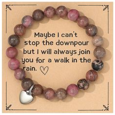 a beaded bracelet with a heart charm and saying maybe i can't stop the downpour but i will always join you for a walk in the rain