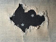 an old torn piece of fabric with silver stars on black and white background, showing the ripped edges