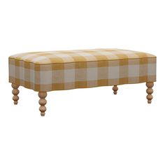 an upholstered bench with wooden legs and checkered fabric