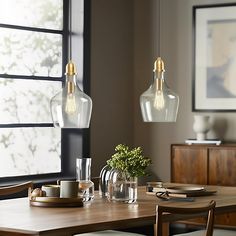 a dining room table with two hanging lights above it