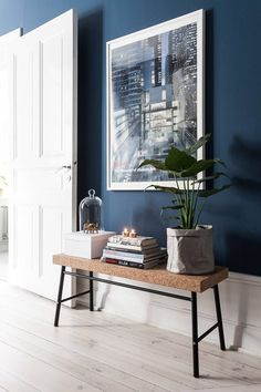 a living room with blue walls and white furniture, including a bench in front of the door