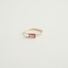 From our birthstone collection this exquisite natural ruby features a rare and delicate pink hue, radiating elegance and sophistication.  Celebrate the vibrancy of July with this stunning emerald-cut ruby crafted in 14K gold. Materials:  14K Solid gold .35 ct. Natural Ruby .79 Gold grams    Care Instructions: Storage: Store your jewelry in a cool, dry place, preferably in a fabric-lined jewelry box or pouch. Keep pieces separate to avoid scratching. Avoid Chemicals: Keep your jewelry away from harsh chemicals, such as bleach, chlorine, and household cleaners. These can damage metals and dull gemstones. Regular Cleaning: Clean your jewelry regularly with appropriate methods to maintain its brilliance and prevent buildup of oils and dirt. Timeless Emerald-cut Ruby Ring, Pink Emerald Cut Ruby Ring In Fine Jewelry, Emerald Cut Pink Ruby Ring In Fine Jewelry Style, Luxury Ruby Baguette Cut Jewelry, Baguette Cut Tourmaline Jewelry For Weddings, Lab-created Ruby Baguette Cut Jewelry, Elegant Pink Ruby Gemstone Ring, Elegant Emerald Cut Tourmaline Jewelry, Elegant Pink Ruby Ring