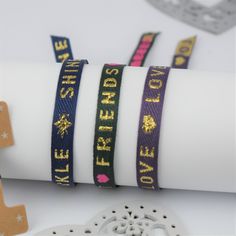 These gorgeous Cute Ribbon Text Bracelets are the perfect gift for BFFs! Buy one and get another for free--it's like a two-for-one deal with double the cuteness! Each set comes mounted on a card and presented in an organza gift pouch, so you can split them up for layering or gift them to your bestie! Now there is no excuse not to have some fun with fashion! Set of two cute Ribbon Text Bracelets that are easy to adjust and one size fits all. The perfect gift for friends to share or keep both to wear and layer. Our cheerful series of ribbon text bracelets are a real must have! Your set of two bracelets are presented on a high quality star print card and sent to you in an organza gift pouch. Choose your favourite text and we'll make sure that bracelet is on the card with one other bracelet fr Trendy Adjustable Name Bangle Bracelet, Trendy Adjustable Bangle Name Bracelet, Adjustable Personalized Bracelets For Parties, Trendy Band Bracelets As Gifts, Gold Friendship Bracelets With Adjustable Band, Trendy Adjustable Wrap Bracelet For Party, Personalized Band Bracelet For Gift, Adjustable Gold Wristband For Friendship, Adjustable Band Bracelets For Everyday