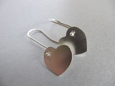 "These earrings are perfect for Valentine's day or any or any gift occasion. I cut the hearts out of sterling silver sheet with my little saw and gave them a soft brushed surface. The ear wires are handmade of sterling silver with a little ball at the end which shows at the front of the heart. Simple, elegant, and sweet. The hearts measure approx. 5/8\" by 5/8\" (16mm by 16mm)" Sterling Silver Heart Charm Earrings For Mother's Day, Minimalist Sterling Silver Earrings For Valentine's Day, Sterling Silver Earrings For Anniversary, Minimalist Sterling Silver Heart Earrings For Wedding, Sterling Silver Earrings For Mother's Day Anniversary, Sterling Silver Earrings For Anniversary And Mother's Day, Silver Heart Earrings For Anniversary On Valentine's Day, Sterling Silver Earrings For Anniversary Gift, Minimalist Sterling Silver Earrings For Mother's Day