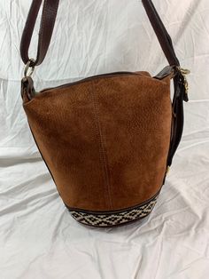 "Measurements are 12\" top wide, 11\"5 high and 9\" deep with one 35\" shoulder strap at its longest with a 10\" drop. There is one large main compartment, lined in beige fabric, back wall zipper pocket and a top zipper closure. This lovely bag is made of brown leather with tan pigskin suede, light stitching and gold tone hardware. Bag is vintage and there are light scuffs on the exterior and there are no tears. There is one exterior zipper pocket for easy to access items. ---------------------- Vintage Leather Bucket Bag With Large Capacity, Brown Rectangular Bucket Bag With Leather Trim, Brown Large Capacity Bucket Bag, Vintage Brown Leather Hobo Bag, Brown Bucket Satchel With Adjustable Strap, Retro Leather Hobo Bag With Large Capacity, Vintage Large Capacity Crossbody Bucket Bag, Retro Brown Leather Hobo Bag, Vintage Large Capacity Tote Bucket Bag