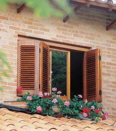 an open window with wooden shutters and flower boxes