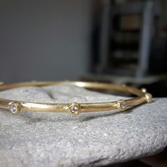 Handcrafted in solid 18k gold, the raw organic texture of this beautiful diamond bangle is contrasted by the brilliant sparkle of white diamonds.  The amorphic little globules are each set with a white 2 point vvs diamond. This diamond bracelet is beautiful by itself, and can also be worn with other bangles in a stack. This bracelet can be ordered without the diamonds, as seen in the last two pictures. Ask me for a quote. Dimensions: > The thickness of the bracelet is about 3 mm  > The inside di Elegant Gold Hand Forged Bracelets, Elegant Hand Forged Yellow Gold Bangle, Elegant Hand Forged Gold Bracelets, Hand Forged Bangle For Formal Occasions, Formal Hand Forged Bangle Jewelry, Formal Hand-forged Bangle Jewelry, Gold Hand Forged Bracelets For Anniversary, Elegant Gold Hand Forged Bangle, Hand Forged Yellow Gold Bangle Bracelets