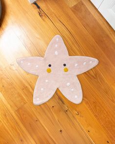 a pink starfish rug sitting on top of a wooden floor