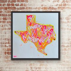 a painting on a brick wall with the shape of texas painted in pink and yellow