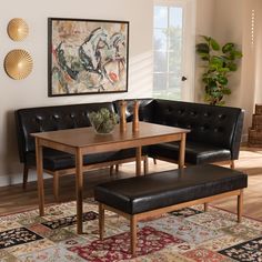 a living room with black leather couches and a wooden table in front of a painting