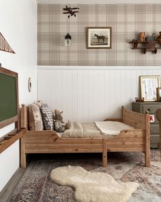 a bedroom with a bed, rug and pictures on the wall above it is shown