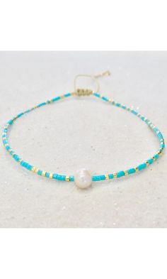 The Dainty Freshwater Pearl Anklet, adorned with gold and pink Miyuki Beads and an adjustable string for a perfect fit, offers a sophisticated yet charming blend of elegance. Anklet Miyuki Beads 6mm Freshwater Pearl Adjustable Nylon cord Made in the United States Style Code: RM-FWP-AHP Adjustable Gold Pearl Bracelet For Summer, Adjustable Dainty Anklets With Colorful Beads, Dainty Adjustable Anklets With Colorful Beads, Elegant Tiny Beads Friendship Bracelets For Beach, Gold Elegant Friendship Bracelets For Beach, Elegant Gold Friendship Bracelets For Beach, Handmade Gold Pearl Bracelet For Summer, Summer Gold Beaded Pearl Bracelet, Gold Beaded Bracelets With Sliding Knot For Summer