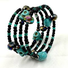 This Black And Teal Memory Wire Wrap Bracelet Is Made With Czech Fire Polished Beads, Dark Iris Rainbow Ab Crystals, And Turquoise Candy Skull Beads For An Awesome Piece Of Arm Candy! Black Hand Wrapped Beaded Bracelets For Festival, Hand Wrapped Black Beaded Bracelets For Festivals, Festival Hand-wrapped Black Beaded Bracelets, Handmade Black Jewelry For Day Of The Dead, Black Skull Bracelets For Festival, Adjustable Handmade Skull Bracelets, Black Hand Wrapped Bracelets For Festivals, Black Hand Wrapped Festival Bracelets, Black Hand Wrapped Wrap Bracelet For Festival