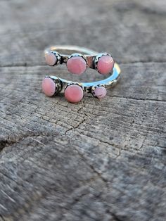 Wrap your finger in the beauty of the ocean with our Six Shell Wrap Around Ring. Made with six stunning pink conch shells, this ring brings the calming and soothing energy of the sea to your everyday look. Perfect for anyone who loves beachy vibes and unique jewelry. Handmade Ocean-inspired Pink Jewelry, Handmade Pink Ocean-inspired Jewelry, Pink Shell Ocean-inspired Jewelry, Handmade Pink Toe Ring Jewelry, Handmade Pink Toe Ring, Pink Adjustable Open Ring Jewelry, Bohemian Shell-shaped Pink Jewelry, Handmade Pink Shell-shaped Jewelry, Pink Stackable Open Ring Jewelry