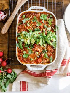 a casserole dish filled with beans, avocado and cilantro