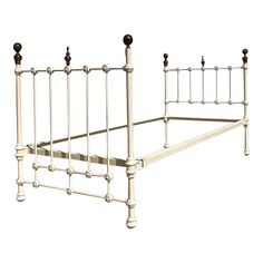 a white metal bed frame with black knobs on the headboard and foot board