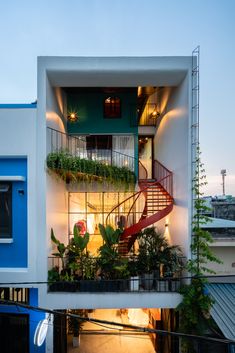 an apartment building with plants on the balconies and stairs leading up to the second floor